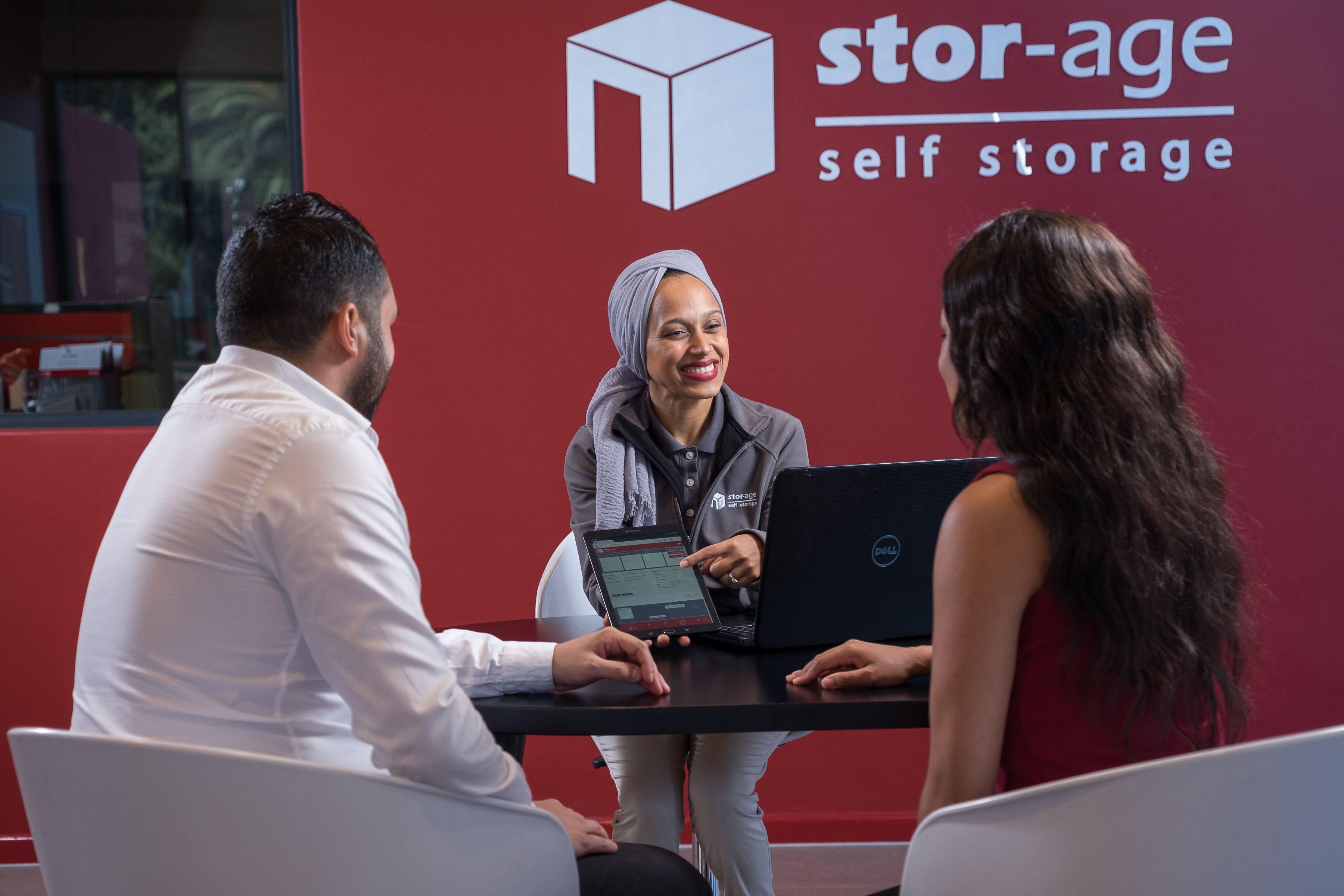 Stor-Age employee helping two clients.